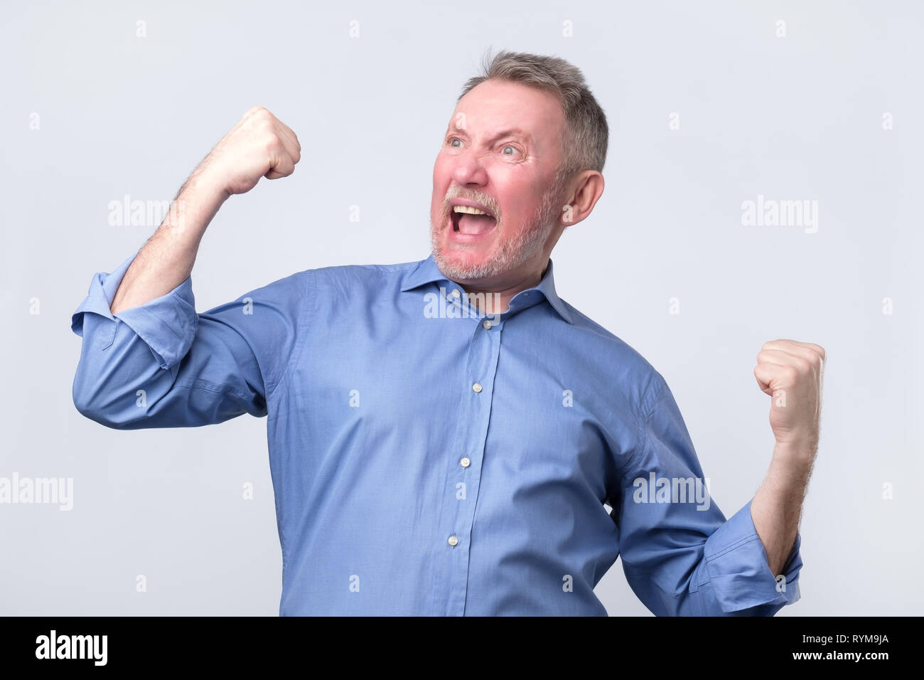 Happy Senior Strong Man Raising Clenched Fists In Hooray Gesture 