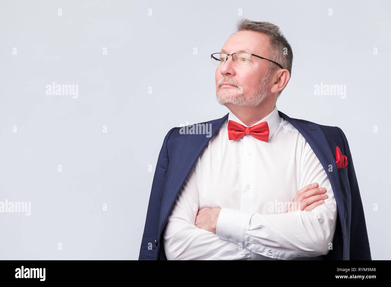 Senior man wearing eyeglasses aand blue suit smiling warmly and confident. Stock Photo