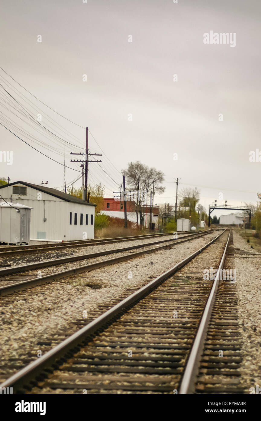 Railway tracks disappearing into the distance. A white shed along with a signal gantry is also visible. Pontiac, Michigan, USA. Stock Photo