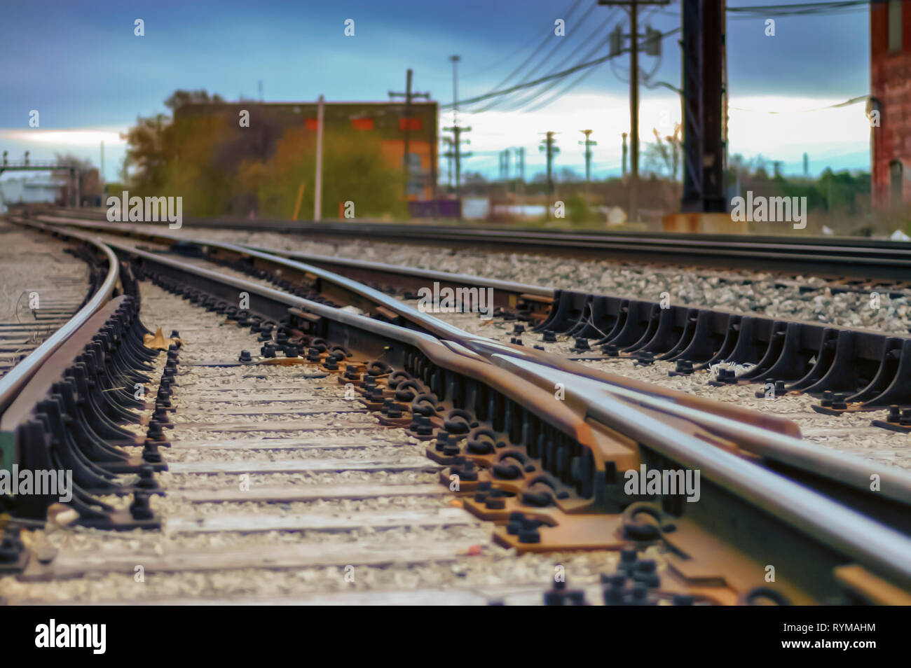 A low angle shallow depth of field shot of railway tracks curving and converging into the distance. Bokeh for creative effect. Pontiac, Michigan, USA. Stock Photo