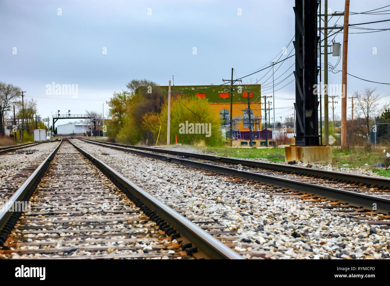 Railway tracks converging and disappearing into the horizon. A signal gantry is visible at the distance. Pontiac, Michigan, USA. Stock Photo