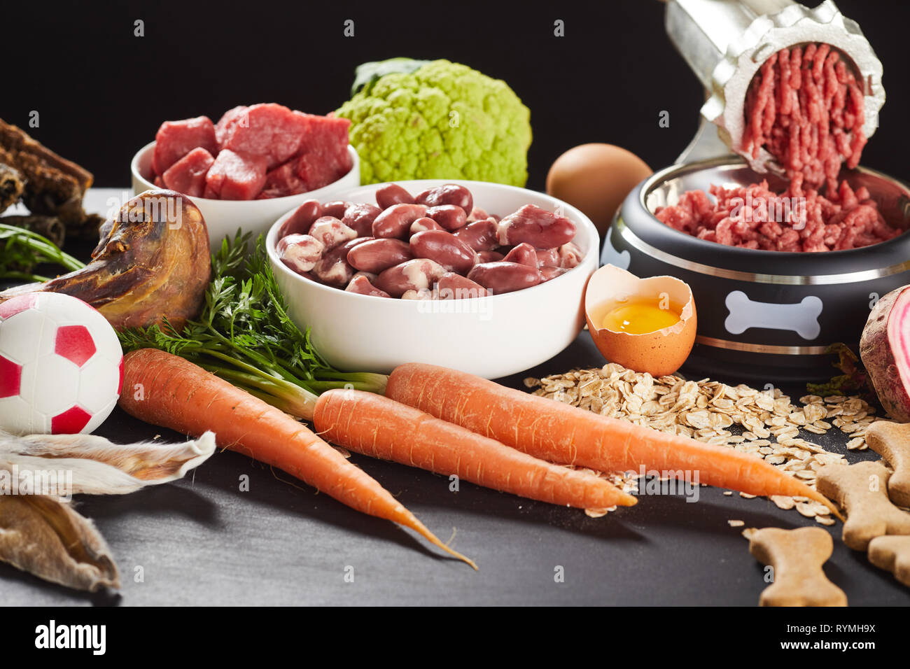 https://c8.alamy.com/comp/RYMH9X/preparing-raw-barf-food-for-a-pet-dog-or-cat-mincing-offal-beef-organs-and-poultry-with-assorted-vegetables-oats-and-egg-yolks-to-serve-with-biscuit-RYMH9X.jpg