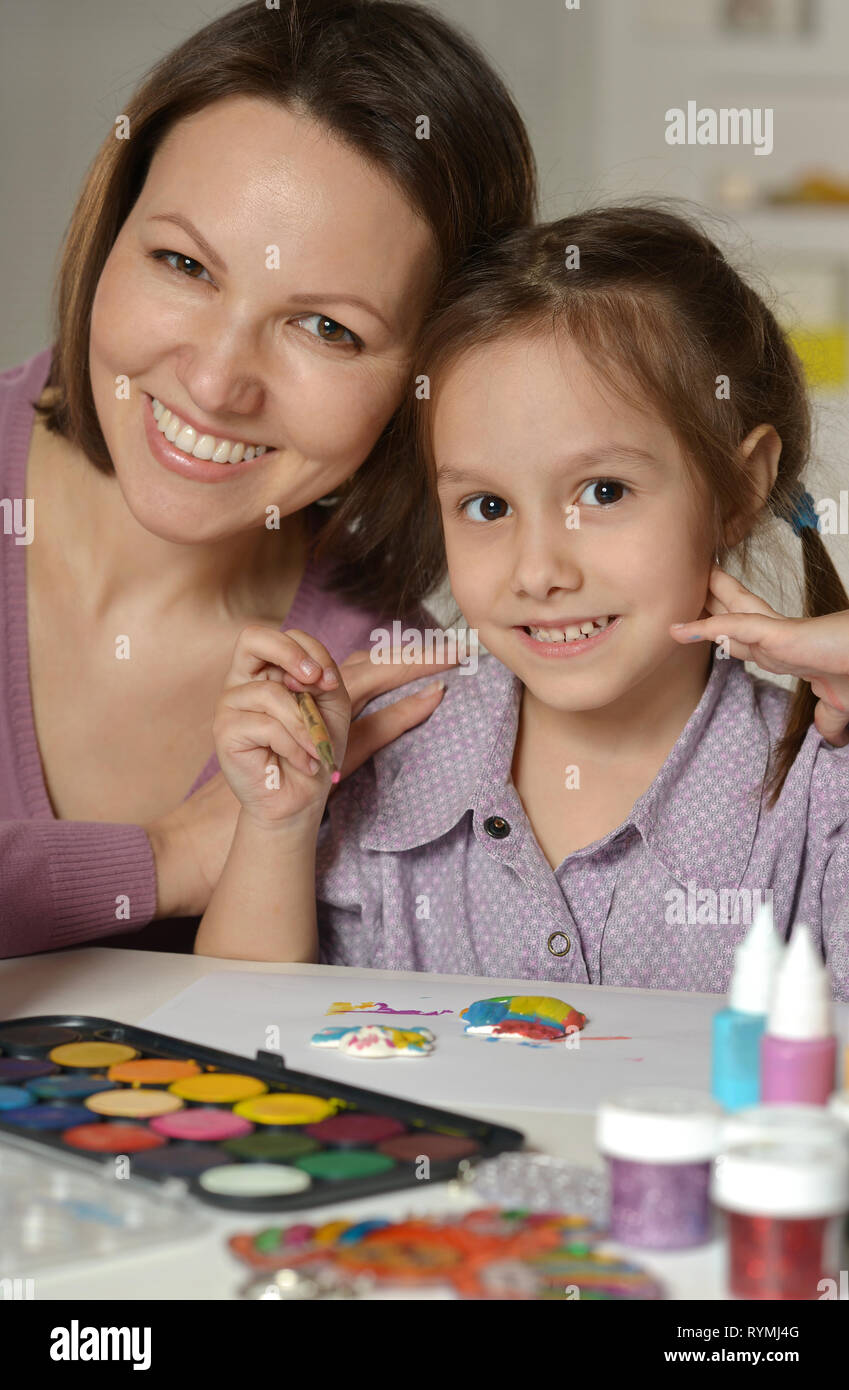 Portrait of mother and little girl painting at home Stock Photo - Alamy