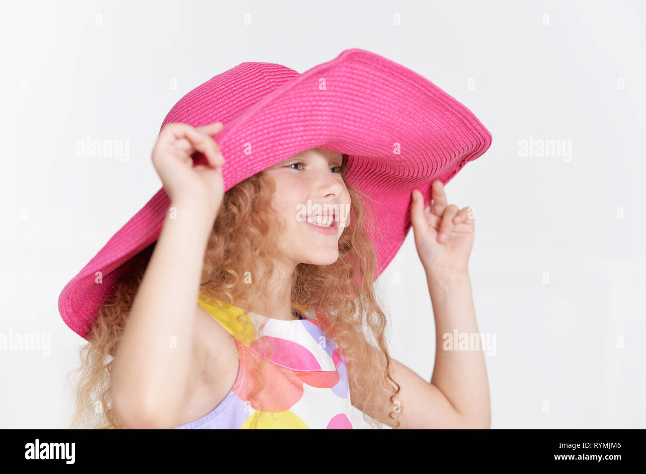 Portrait of smiling little girl posing in beautiful dres on white background Stock Photo