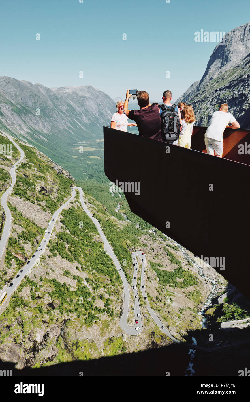 Tourists taking pictures on the Trollstigen viewpoint on the Geiranger-Trollstigen National Scenic Route in Norway - Architect: Reiulf Ramstad Stock Photo