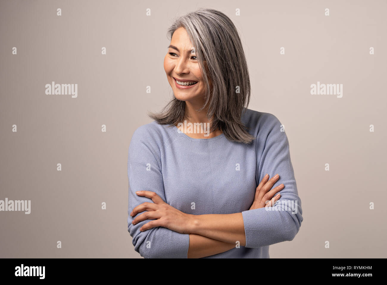 Smiling Asian senior woman with crossed arms Stock Photo