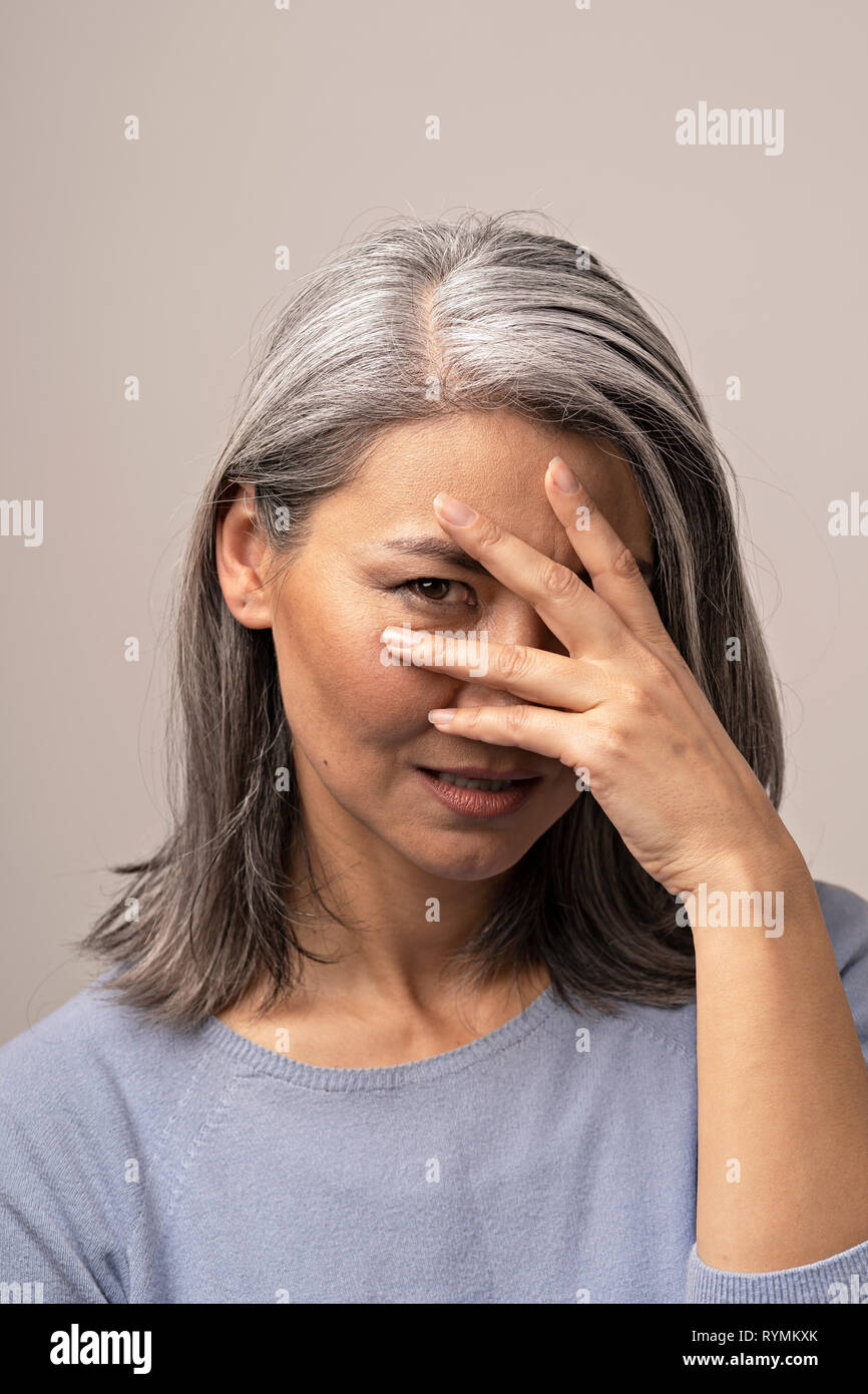 Beautiful woman is peeping through her fingers Stock Photo