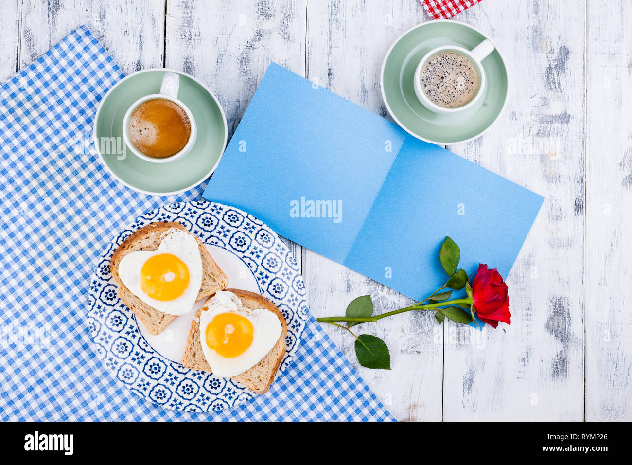 Flowers, Two cups of aromatic coffee and heart-shaped toasts for a romantic morning of lovers. Red rose, letter or note on the table. The concept of V Stock Photo