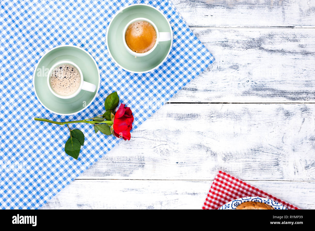 Two cups of aromatic coffee and heart-shaped toasts for a romantic morning of lovers. Red rose and morning surprise for breakfast. The concept of Vale Stock Photo