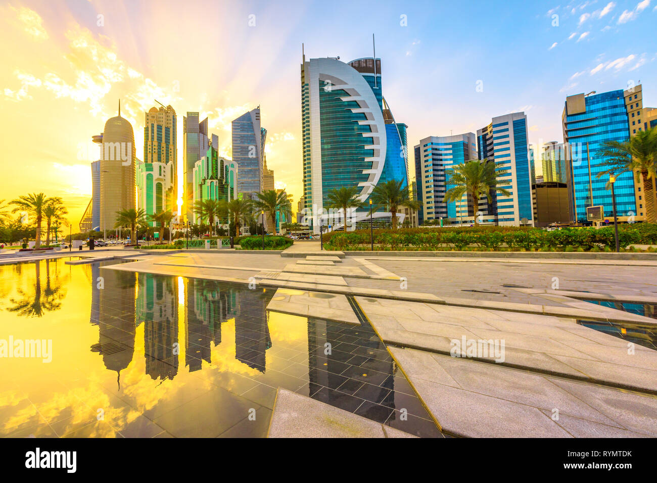 Scenary of Doha West Bay skyline at sunset light reflecting in the water of park in Downtown. Modern glassed skyscrapers of Doha skyline in Qatar Stock Photo