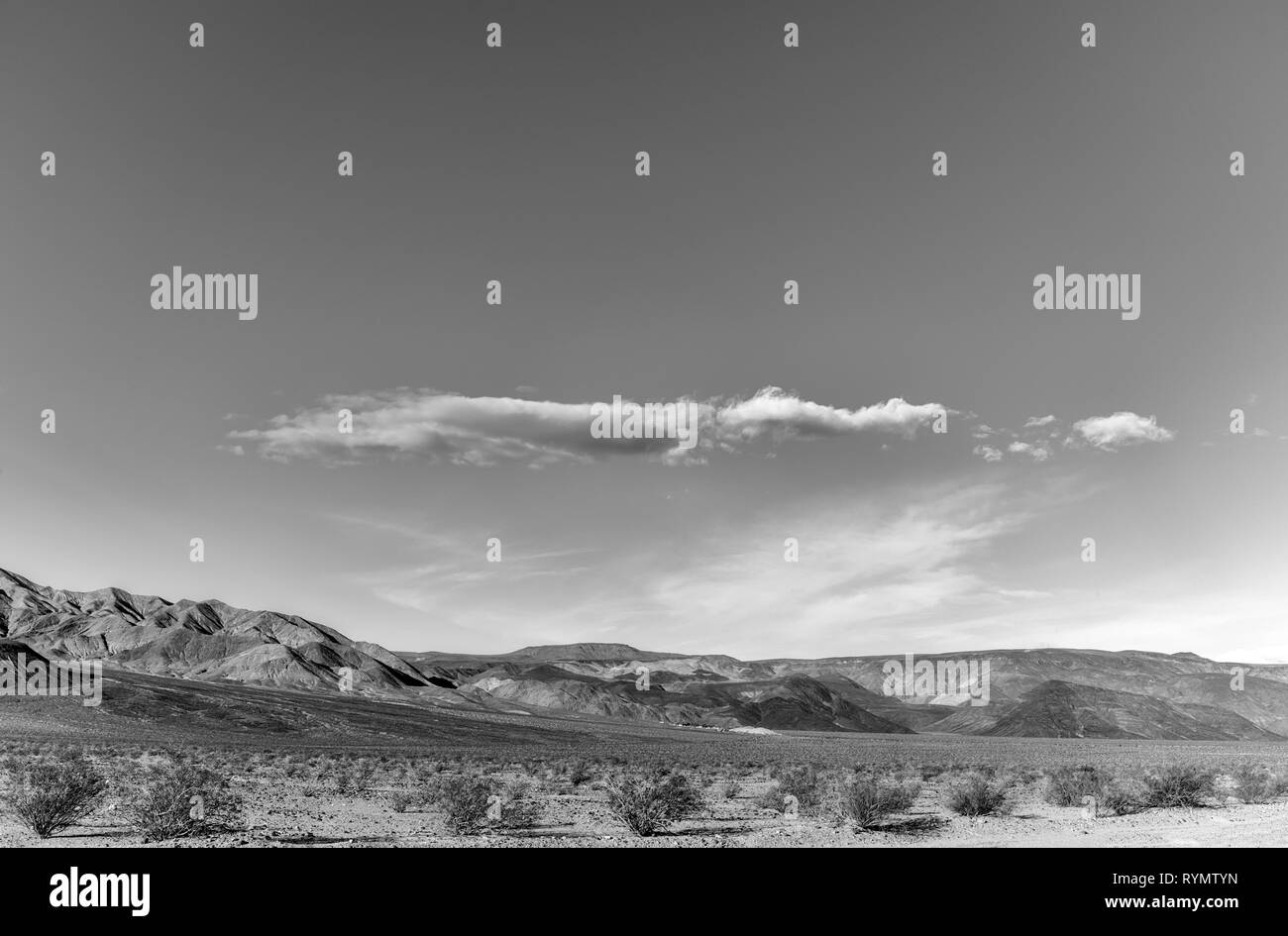 Desolate desert landscape with barren mountains beyond. Stock Photo
