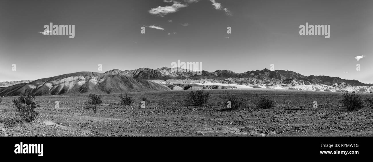 Black and white panoramic desert landscape, valley and barren mountains beyond. Stock Photo