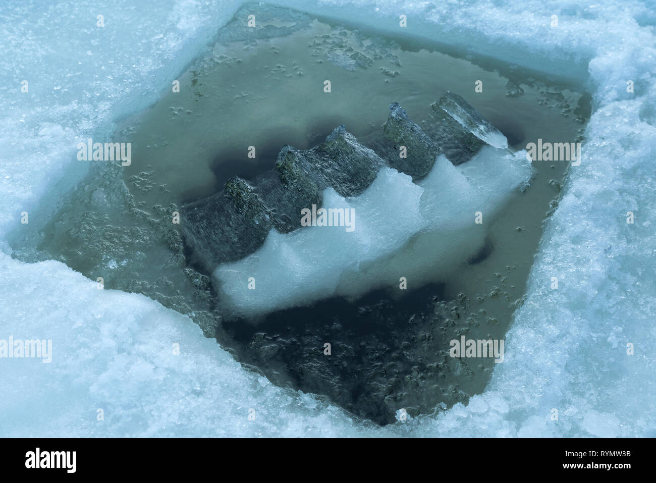 Big piece of ice in a hole made in a frozen mountain lake Selective focus  Stock Photo - Alamy