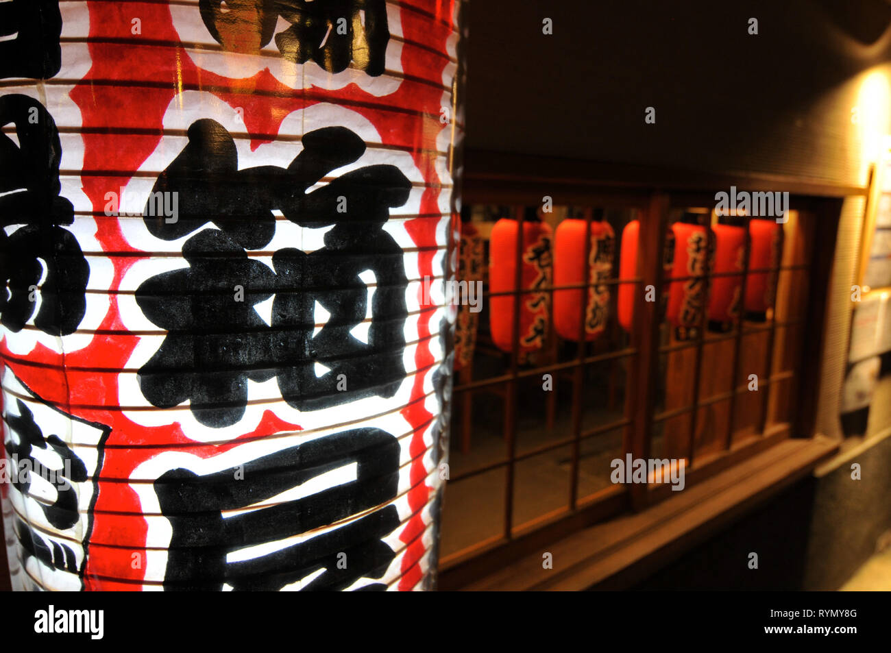 Close up of some Japanese lanterns hanging in front of a restaurant in Kyoto - the translation is 'Speciality Hoden food & Sake' Stock Photo