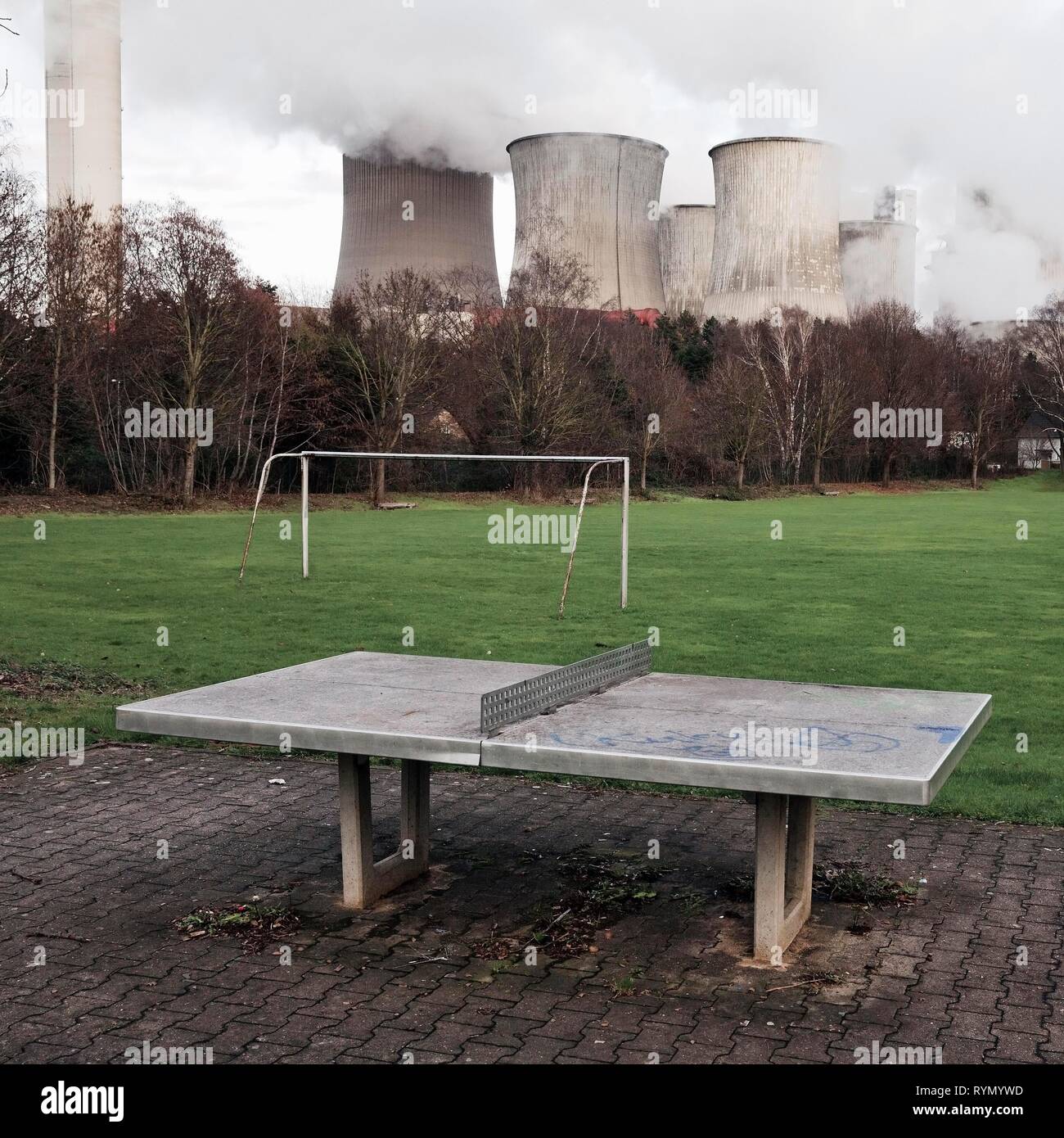 Dreary playground in the Auenheim district in front of the steaming lignite-fired power plant Niederaussem, coal phase-out Stock Photo