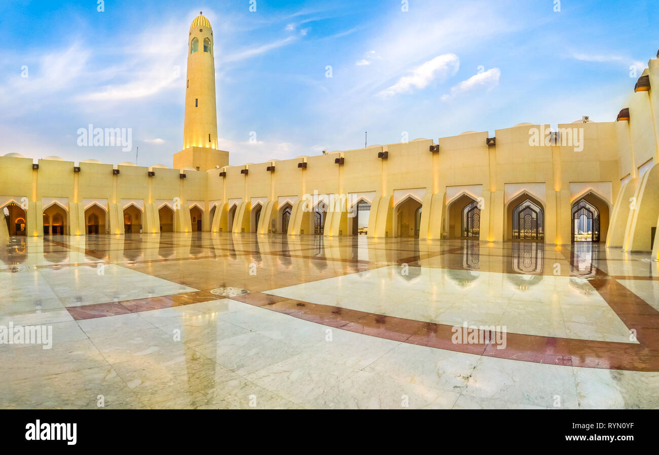 Doha, Qatar - February 21, 2019: panoramic courtyard with minaret and domes reflecting at blue hour. Imam Abdul Wahhab Mosque or Qatar State Mosque in Stock Photo
