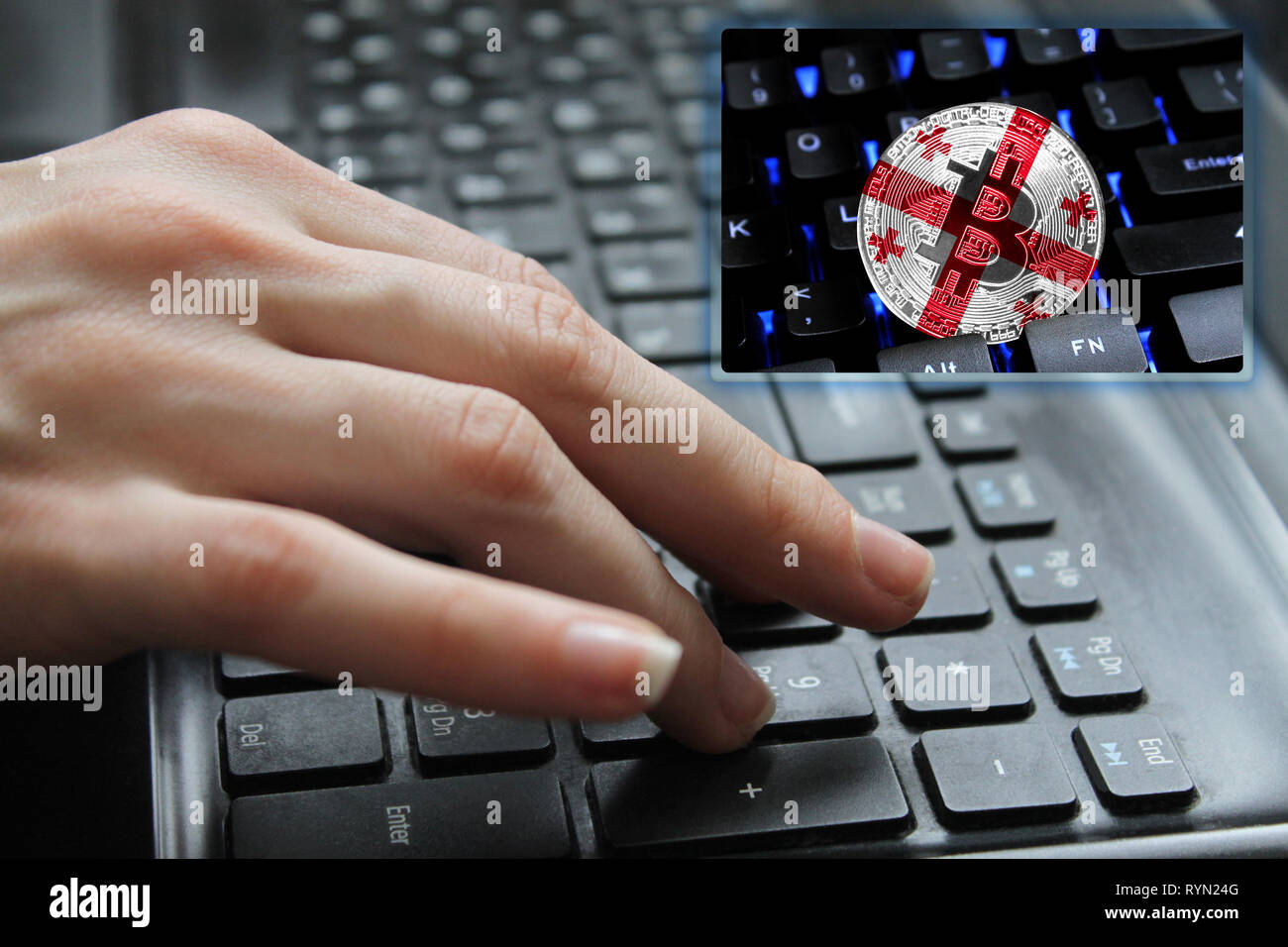 Hand of the girl on the keyboard close up with the concept of digital technology on the purchase and sale of crypto currency bitcoin with a flag of Ge Stock Photo