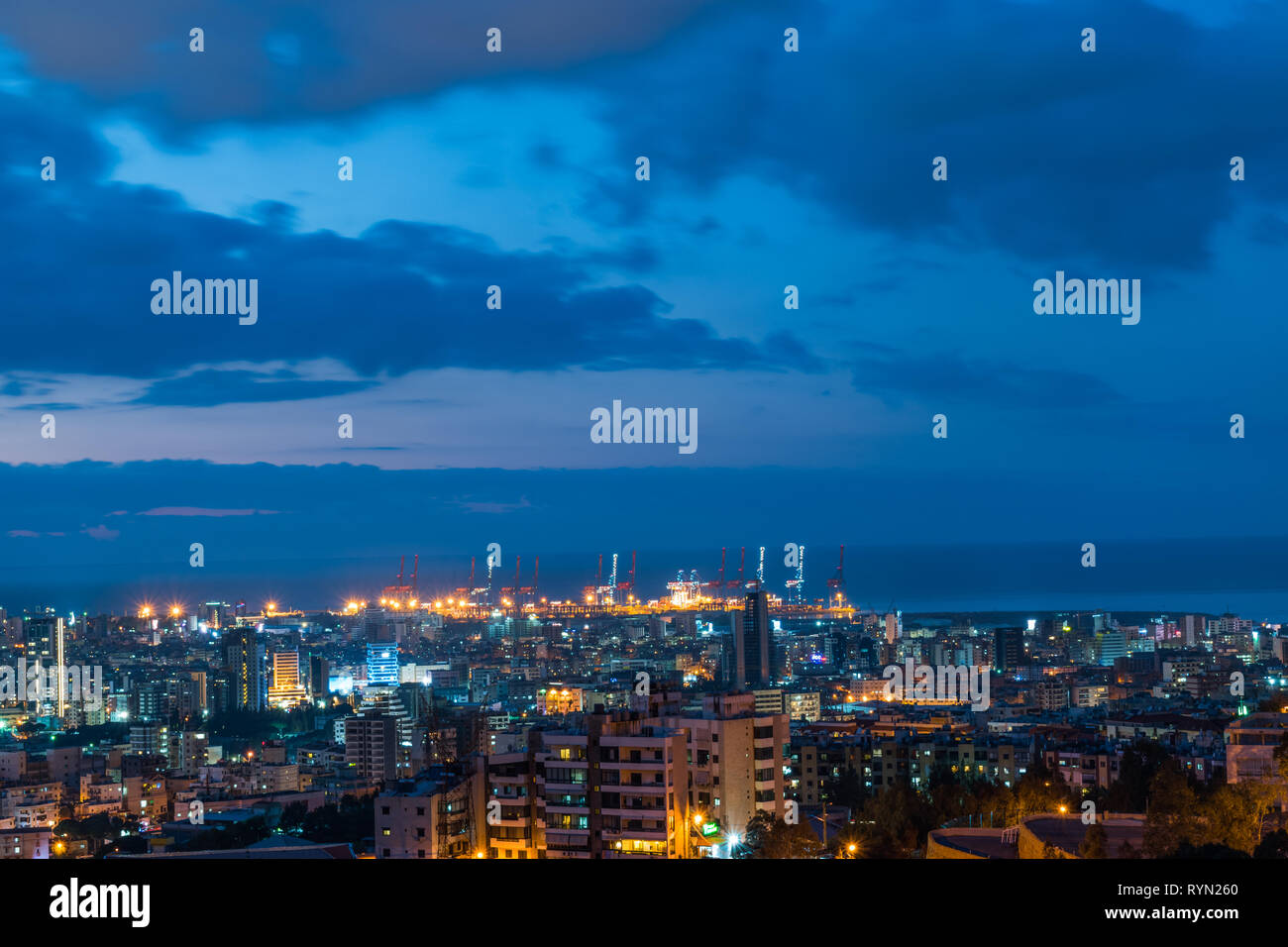 This is a capture of the sunset in Beirut capital of Lebanon with a warm orange color and cool tone cloud and you can see Beirut port in the picture. Stock Photo