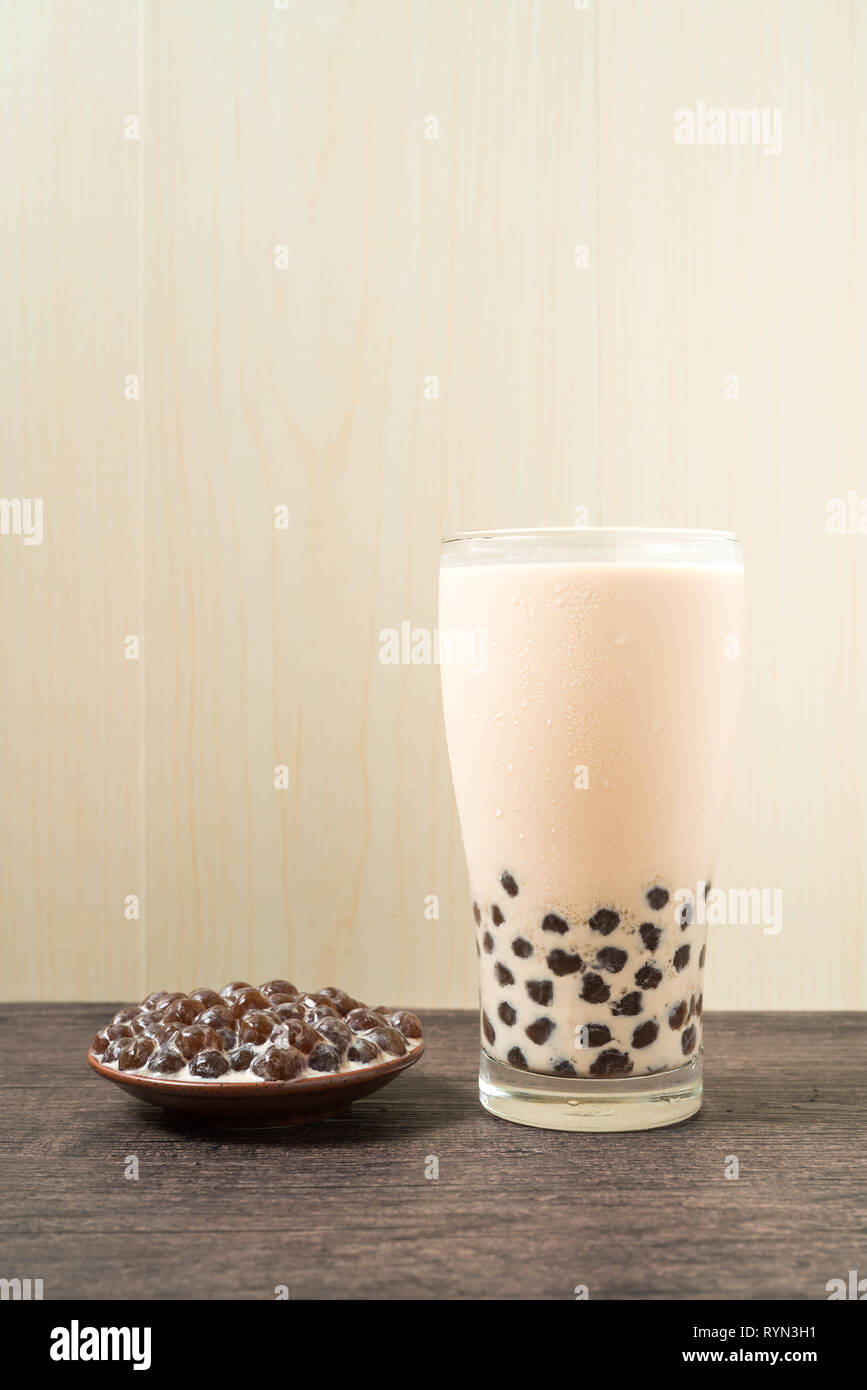 https://c8.alamy.com/comp/RYN3H1/a-glass-cup-of-pearl-milk-tea-also-called-bubble-tea-and-a-plate-of-tapioca-ball-on-wooden-background-pearl-milk-tea-is-the-most-representative-dri-RYN3H1.jpg