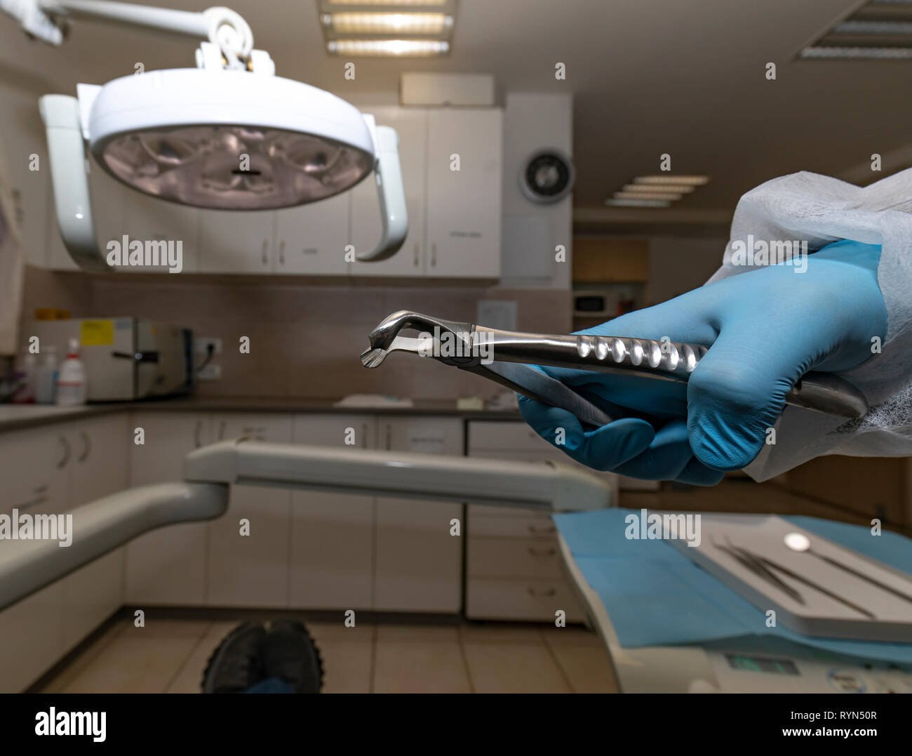 Dental forceps in the hand of the dentist, from the patient's point of