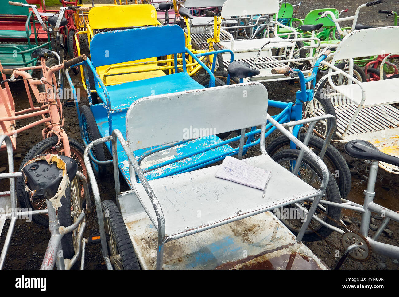Close-up horizontal view of a group of colored old rusty bicycles with side car at an abandoned bike rental in Puerto Princesa City, Palawan, Philippi Stock Photo
