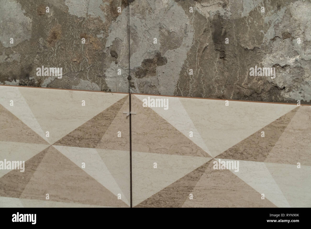 The process of installation of decorative tiles on the wall in the