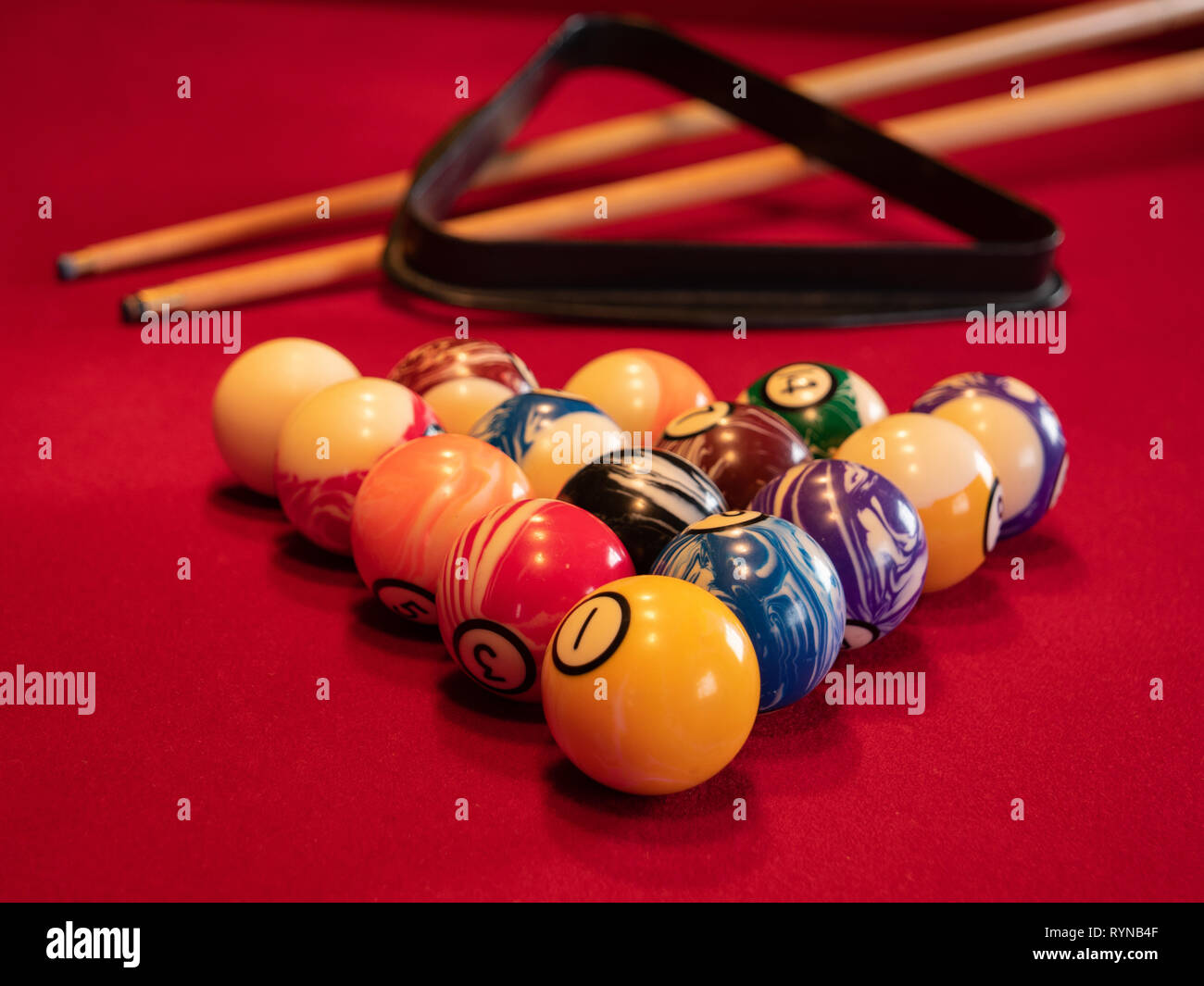 Pool table with balls, cues and triangle Stock Photo