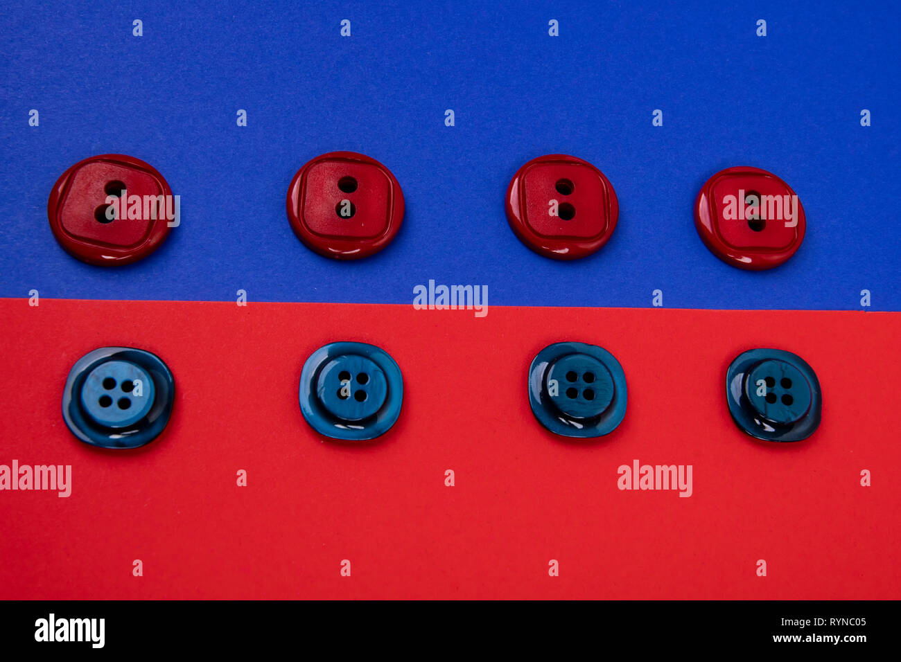 blue buttons on red background and red buttons on blue background separated in the middle Stock Photo