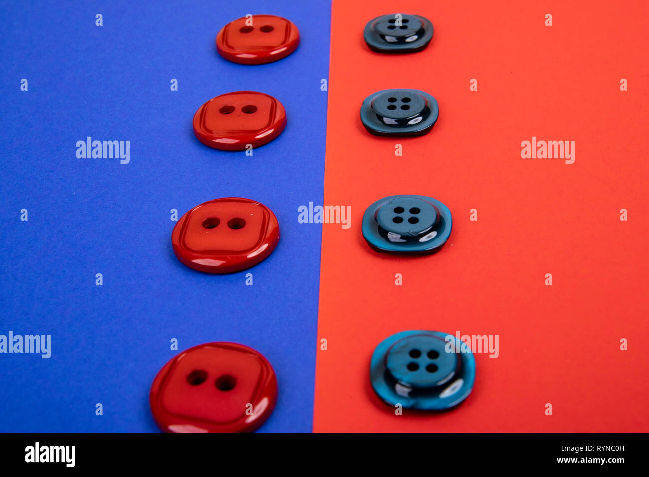 blue buttons on red background and red buttons on blue background separated in the middle Stock Photo