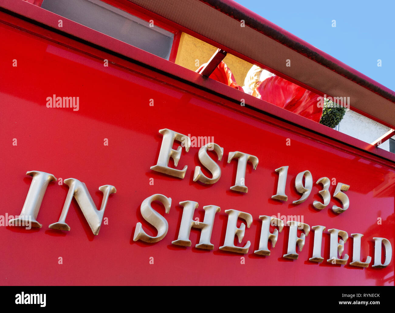 Bright gold letters making a sign on shop front saying Est 1935 in Sheffield Stock Photo