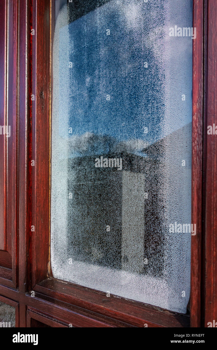 Single glazed door window with condensation forming on the inside of