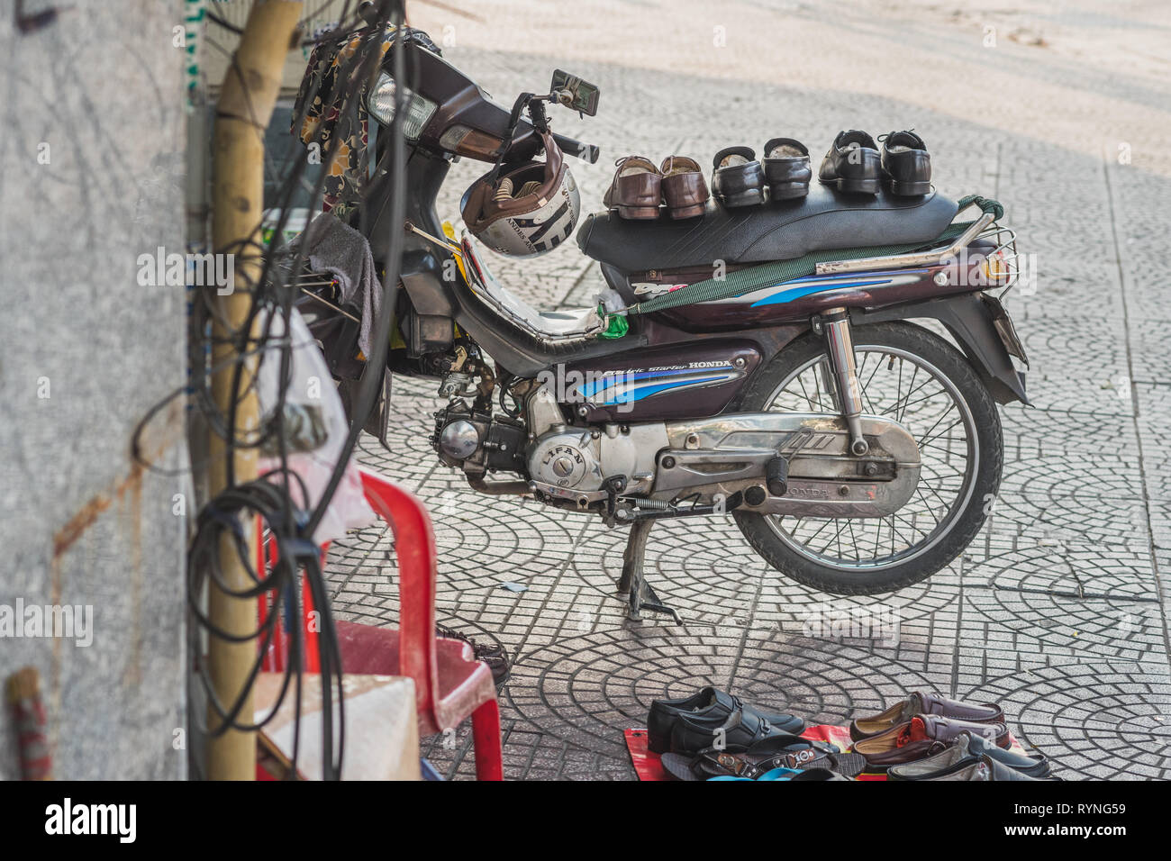 Ho Chi Minh City, Vietnam - January 8, 2019: Selling shoes in the street from the seat of a motorbike. Small business in Saigon. Vietnamese lifestyle. Stock Photo