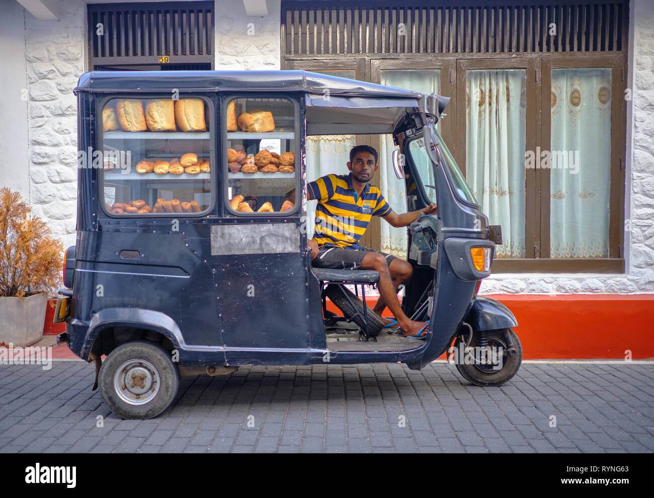 Bread delivery man in black tuktuk in the old part of Galle . Galle