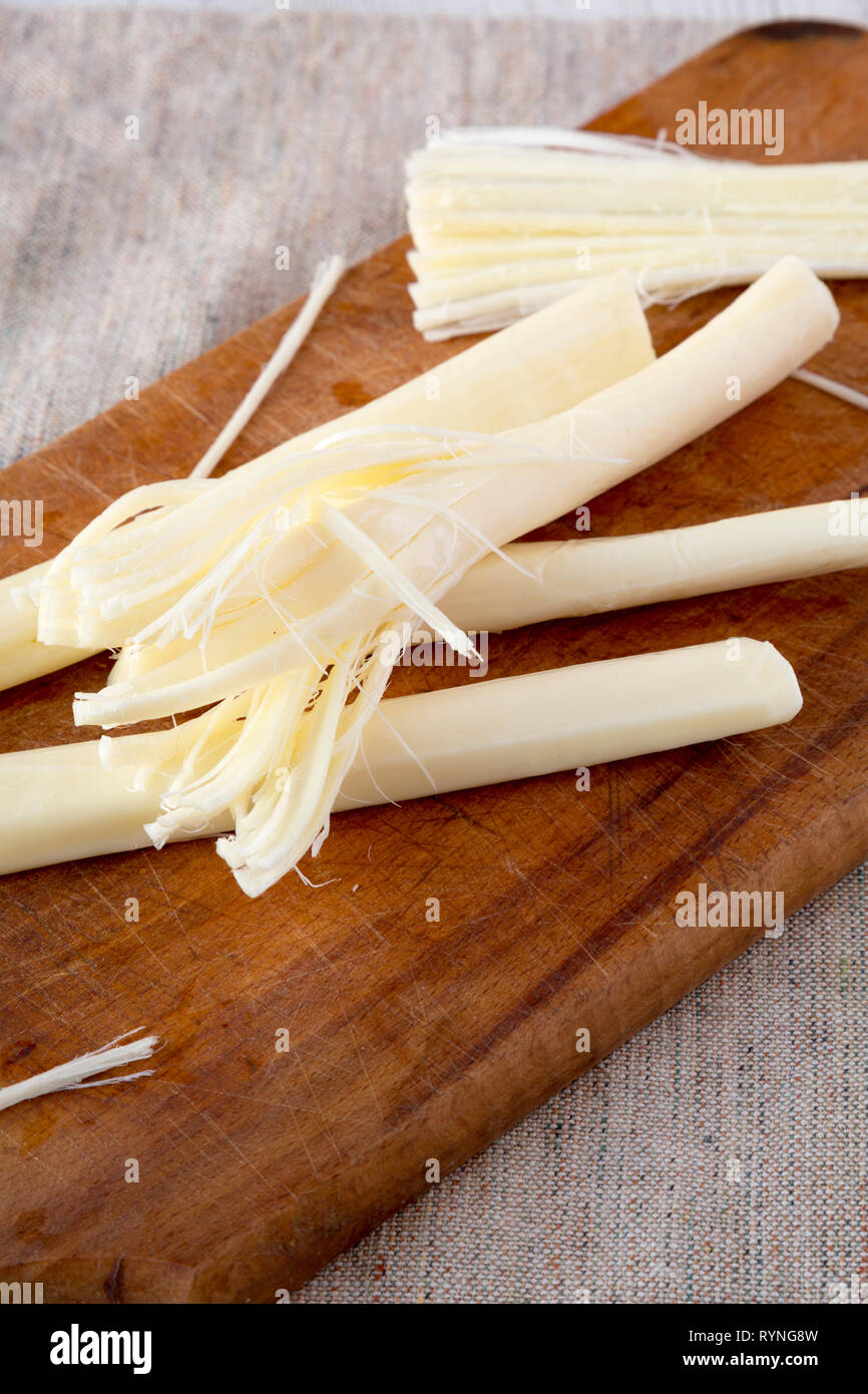 String cheese on rustic wooden board, low angle view. Healthy snack ...