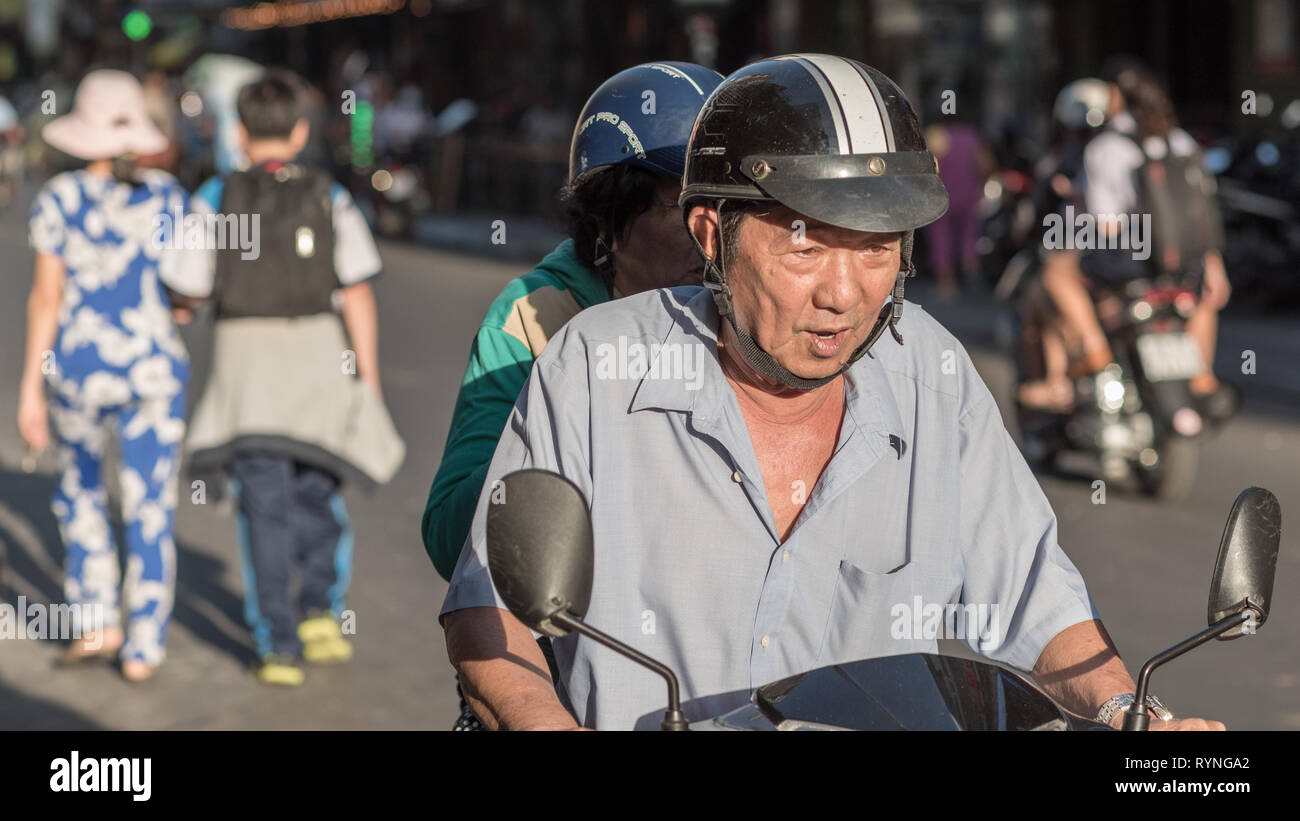 Ho Chi Minh City, Vietnam - January 7, 2019: an elderly man drives a motorbike in the street with an elderly woman behind him. Stock Photo