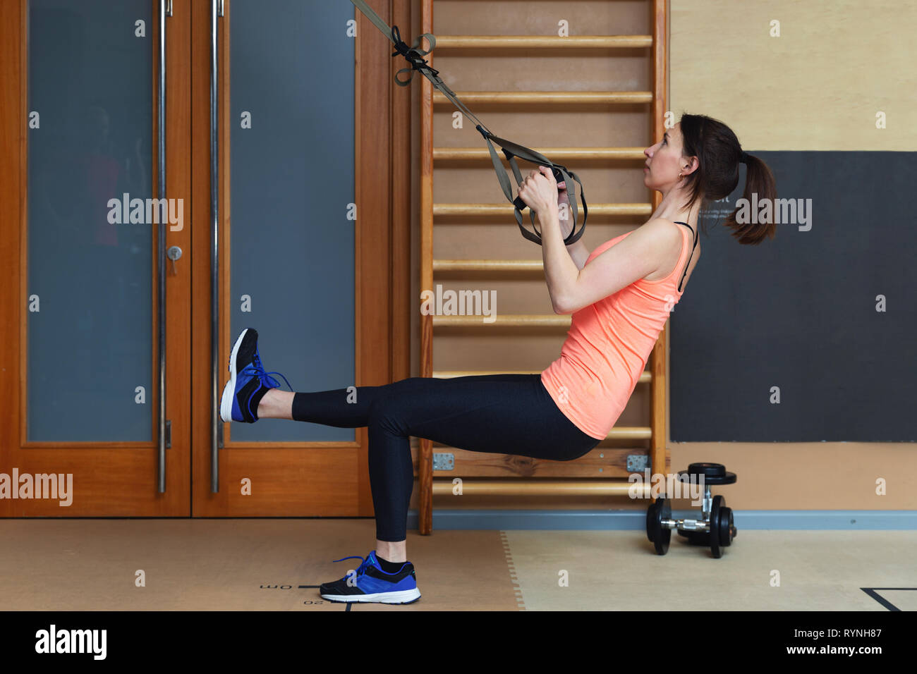 Woman exercising with suspension training trx. Total body resistance exercises Stock Photo