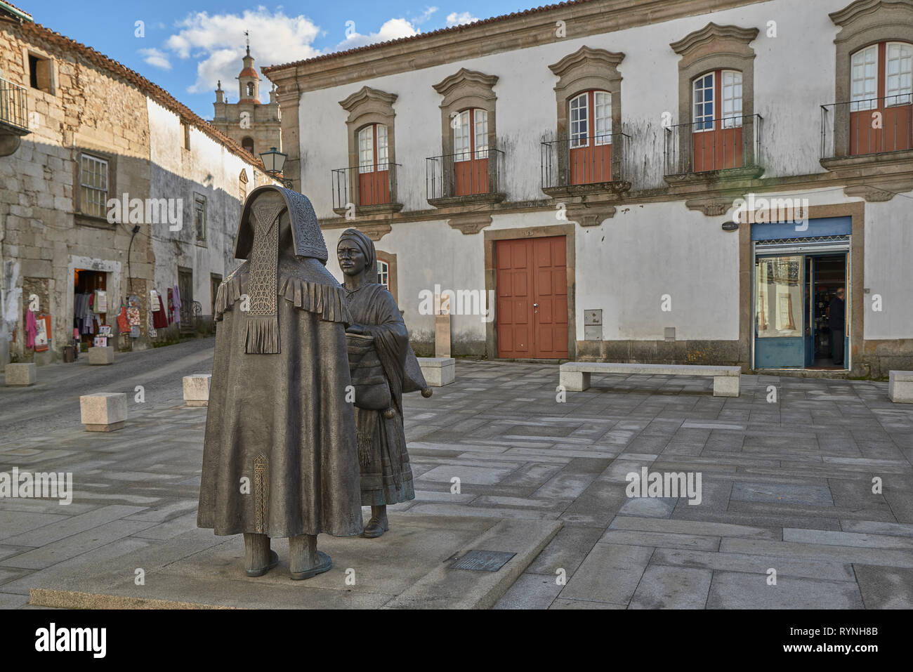 Plaza Joao III, urban sculpture of two statues made in bronze with the typical regional costumes of Miranda do Douro, Portugal, Europe Stock Photo