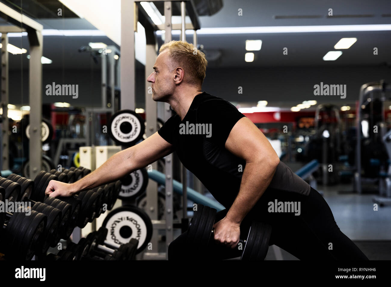 Young man doing the exercises with dumbbell at biceps for good body in fitness gym, bodybuilder, healthy lifestyle, exercise fitness, workout and spor Stock Photo