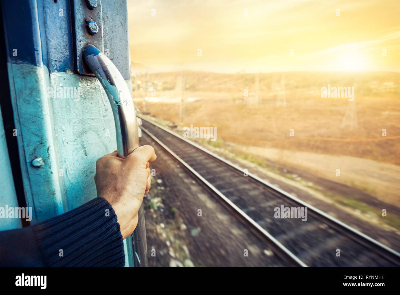 Man in the train passing desert area at sunset sky background in Rajasthan, India Stock Photo