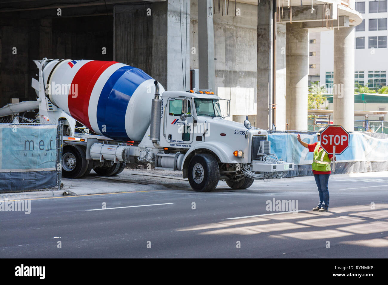 Miami Florida,downtown,concrete mixer,cement truck,under new construction site building builder,building,worker,workers,stop sign,direct traffic,FL090 Stock Photo