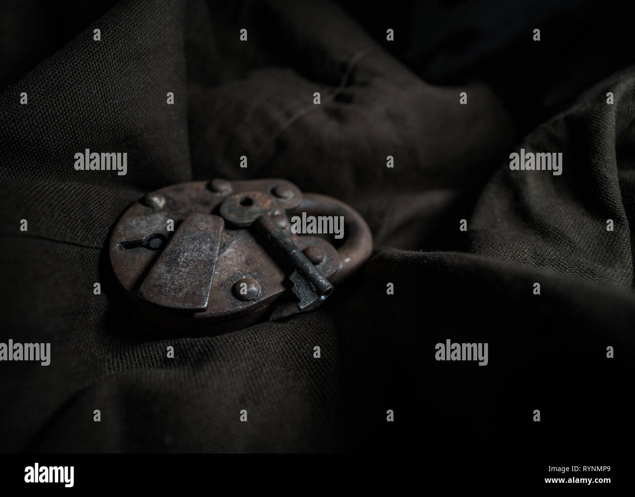 Old Rusted Skeleton Padlock displayed on a textured drop. Stock Photo