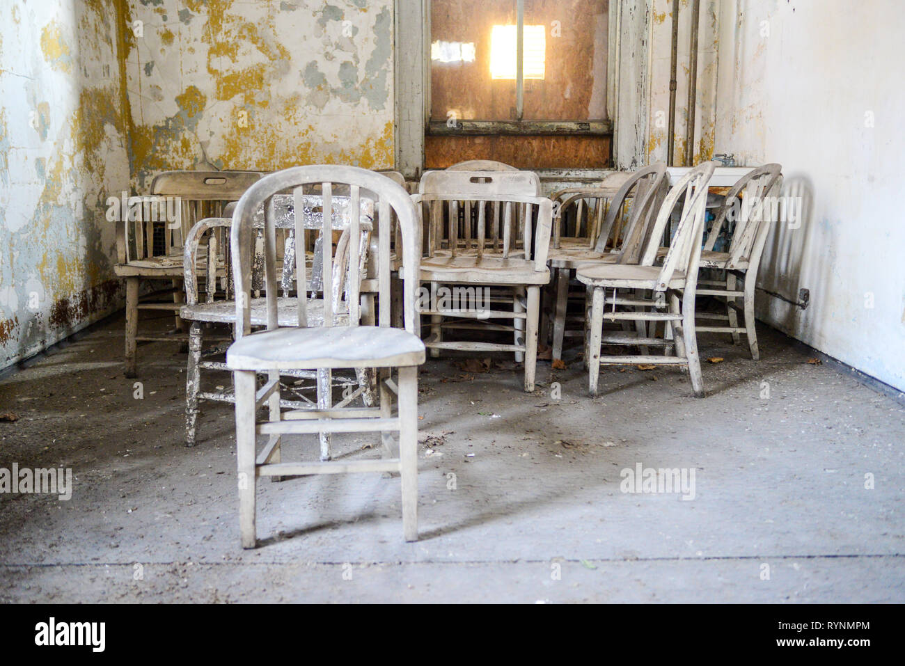 Interior of Decaying Structure Showing Stacked Chairs Stock Photo