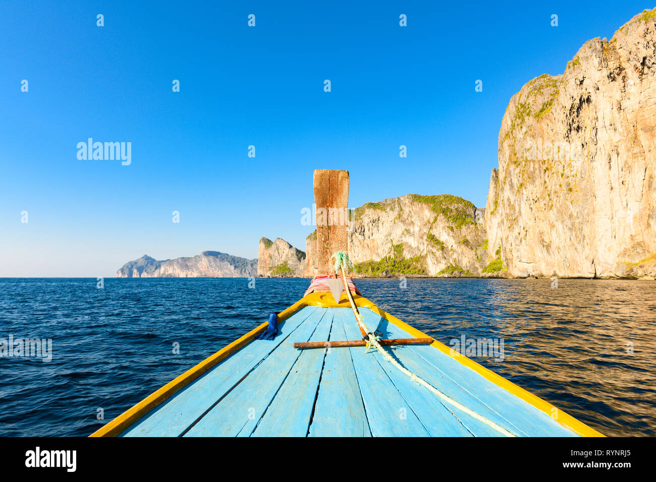 (focus on the boat) Stunning view of some limestone rock mountains surrounding the beautiful Maya Bay. Photo taken from a traditional long tail boat. Stock Photo