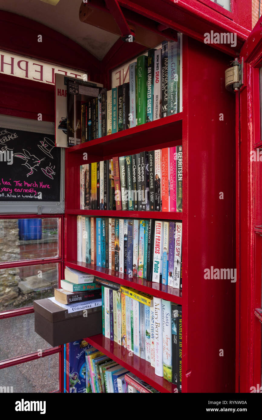 Old red telephone kiosk converted to use as a book exchange in the village of Collingtree, Northamptonshire, UK Stock Photo