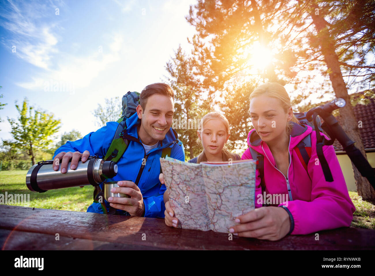 family hikers in forest with map Stock Photo