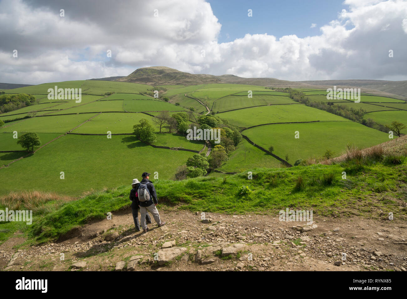 Couple admiring the view in a Peak District landscape on a sunny spring ...