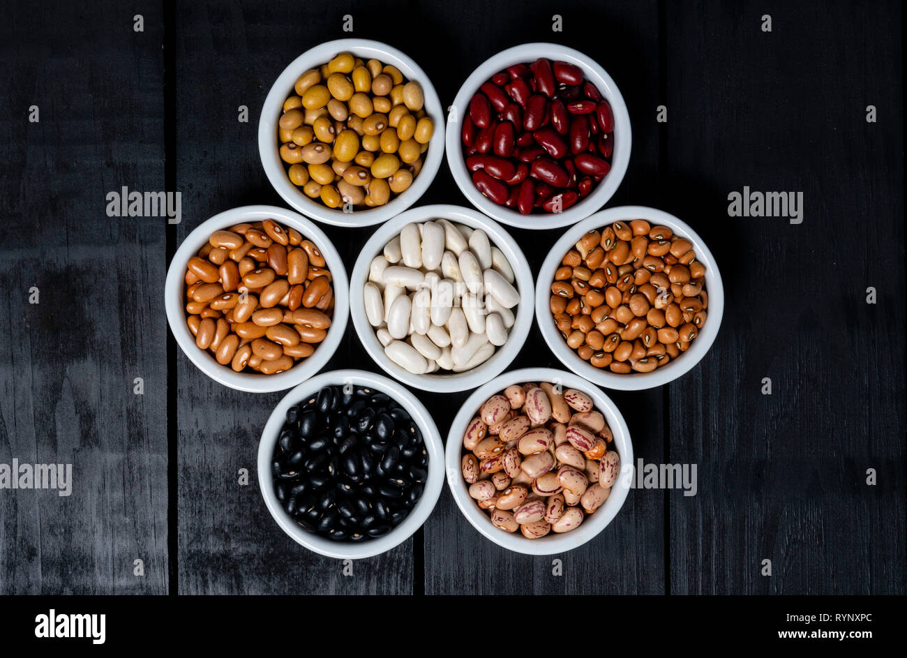 Seven varieties of beans inside white pot on black background Stock ...