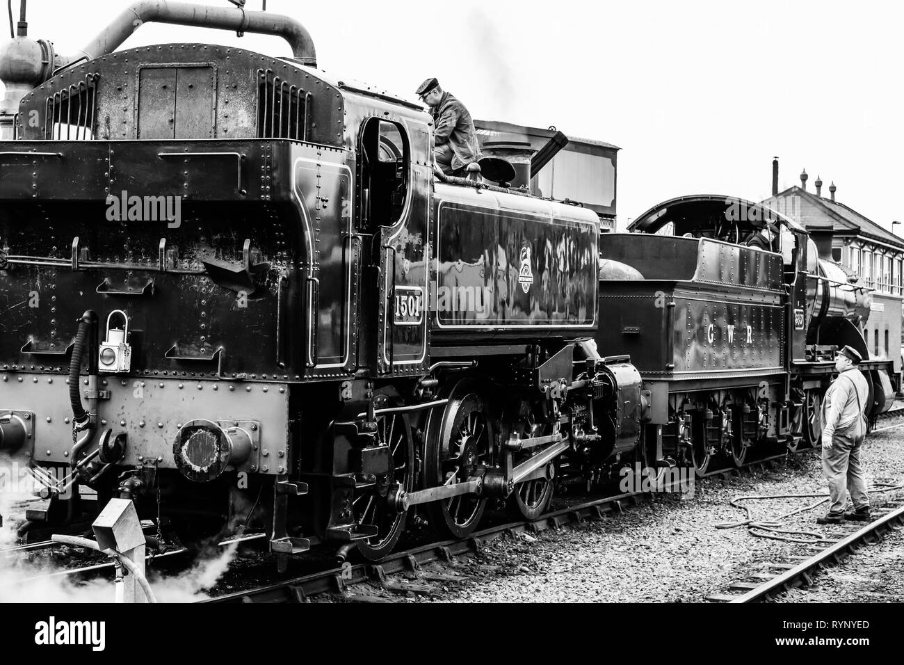 Monochrome close up of two vintage UK steam & train crew on