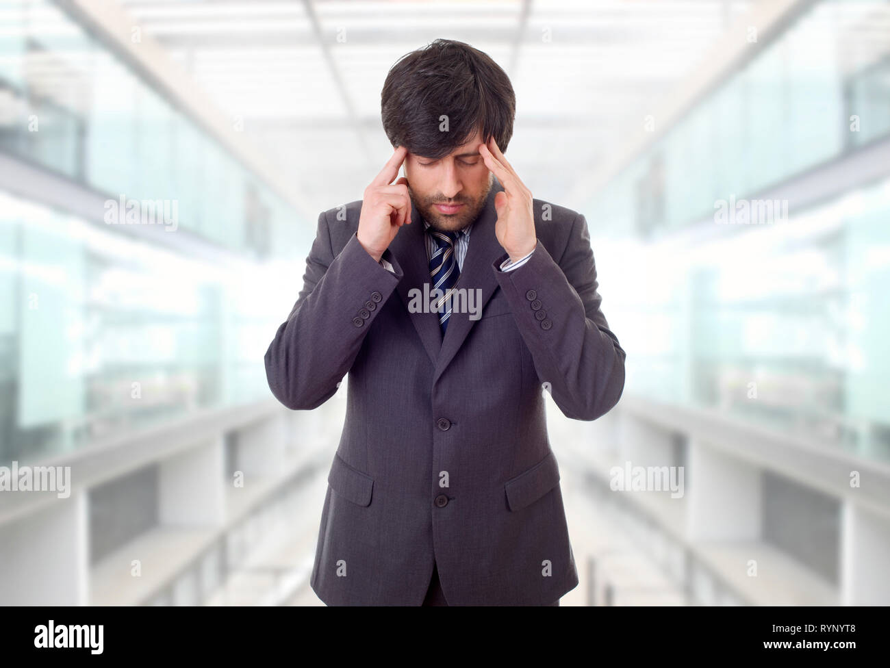 Businessman in a suit gestures with a headache, at the office Stock Photo