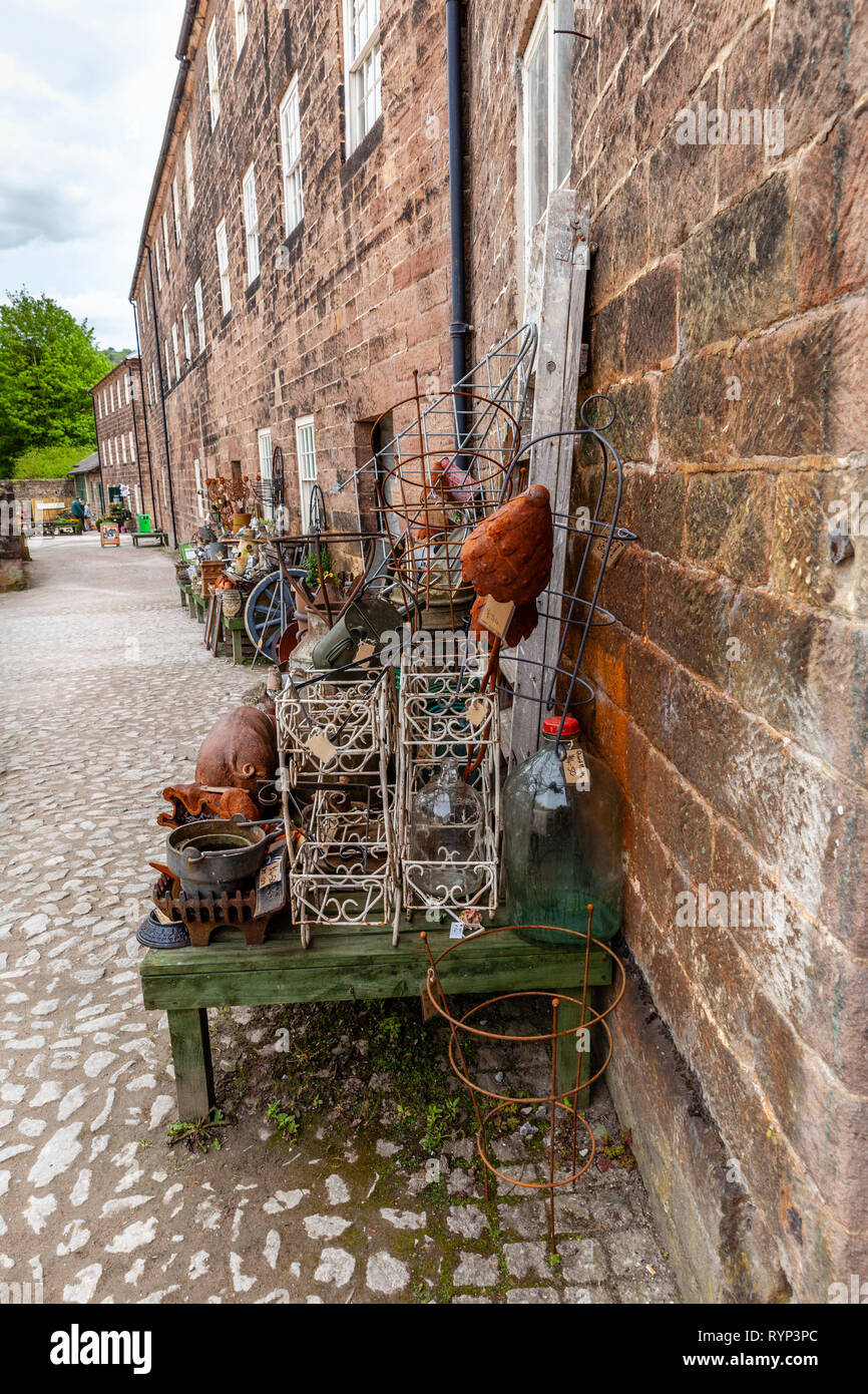 Cromford mill is in Derbyshire, England, And has the bric-a-brac shop, with a lot of the goods on display outside. Stock Photo